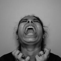 a woman with her mouth open and hands in front of her face